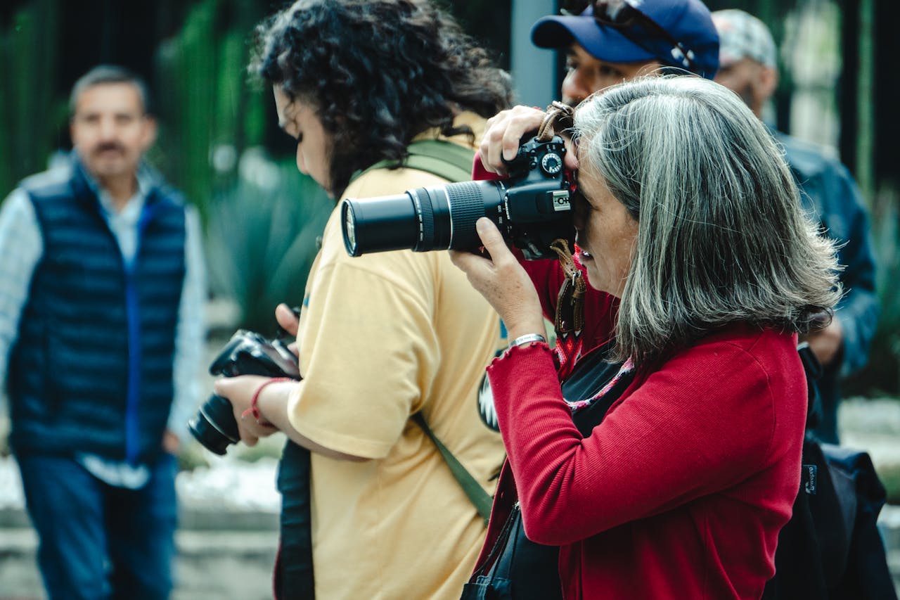 A group of men and women photographers capturing moments outdoors in Mexico City.